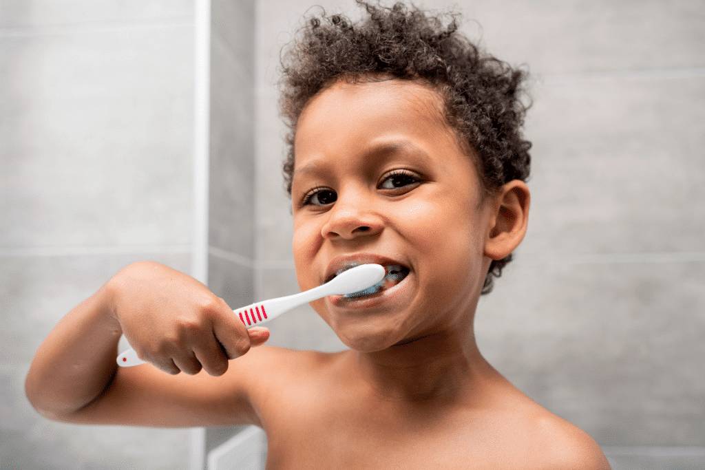 picture of small child brushing their teeth: The Best Food for Kid's Teeth in the Lunchbox
