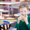 picture of boy smiling and eating sandwich: the best for for kids teeth in the lunchbox