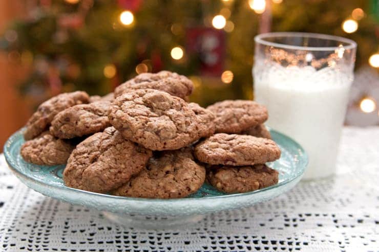 chocolate chip cookies on a plate with a glass of milk waiting for Santa