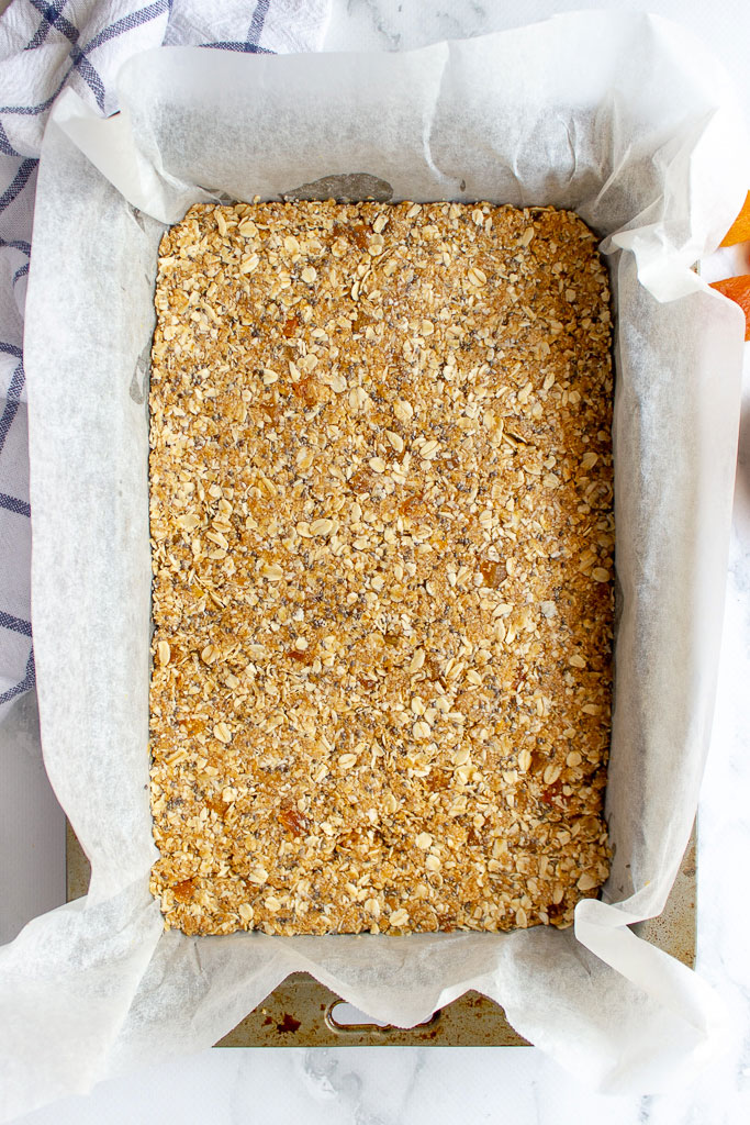 picture of apricot and chia muesli bar mixture pressed into slice pan