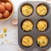 Muffin tin frittatas cooked with bowl of fresh eggs