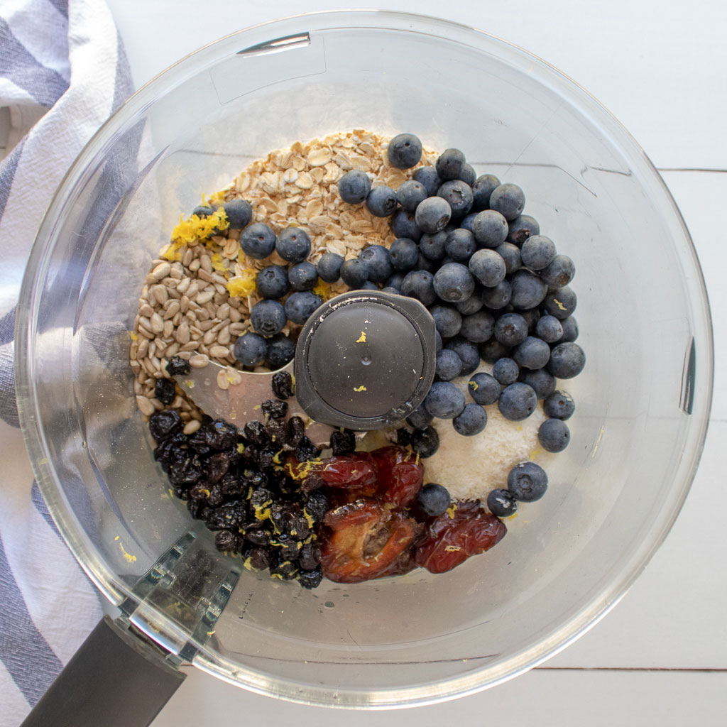 add all the ingredients to make the blueberry bliss balls into a food processor with the s blade 