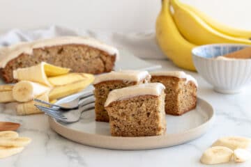 cut banana cake iced with cinnamon cream cheese icing